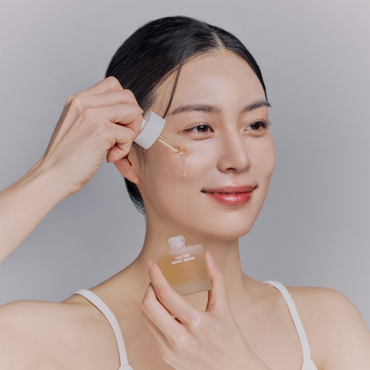 K-Beauty model applying serum